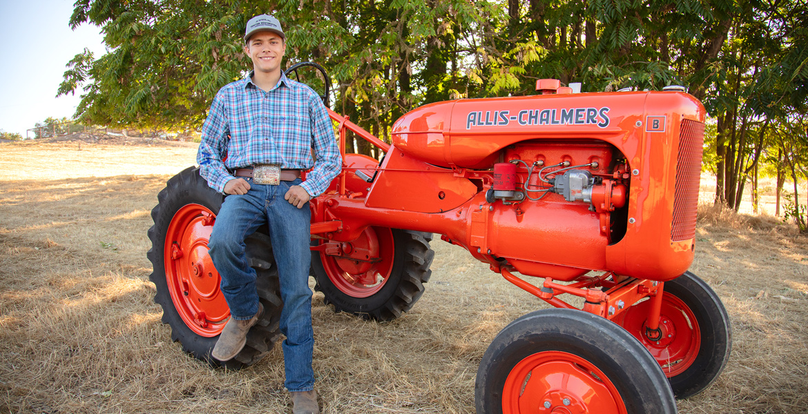 Outdoor Senior Portrait with Bright Orange Tractor - Outdoor Senior Pictures Agriculture Student - FFA Student Senior Portrait - Orange Tractor Passion - Studio 101 West Photography